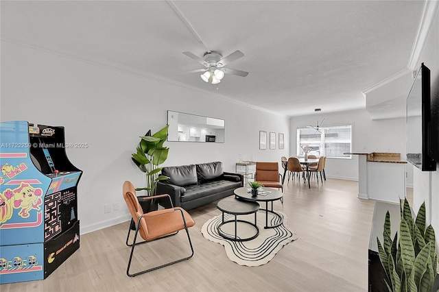 living room with crown molding, light hardwood / wood-style floors, and ceiling fan