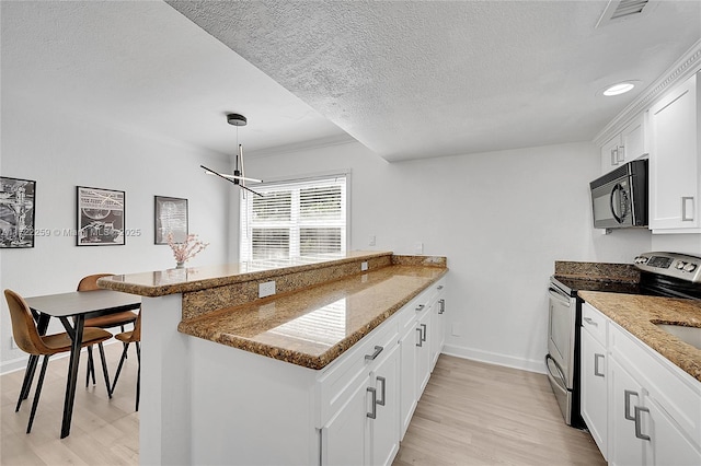 kitchen featuring stainless steel electric range oven, white cabinets, dark stone counters, kitchen peninsula, and light hardwood / wood-style flooring