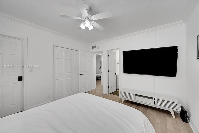 bedroom with ornamental molding, ceiling fan, light hardwood / wood-style floors, a textured ceiling, and a closet