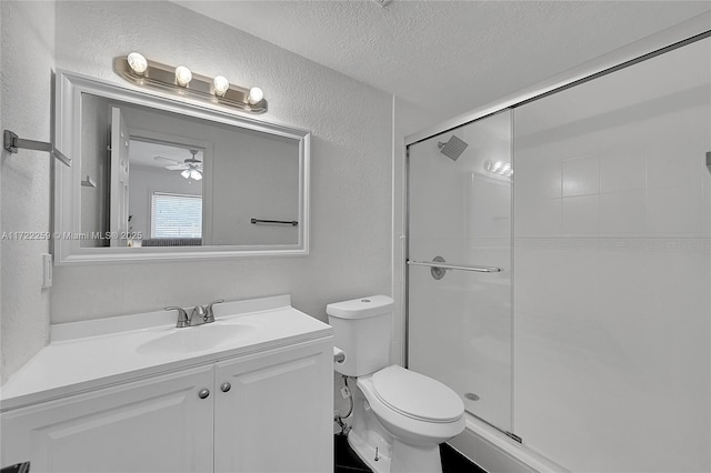 bathroom featuring toilet, vanity, a textured ceiling, and walk in shower