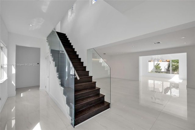 stairway featuring a chandelier