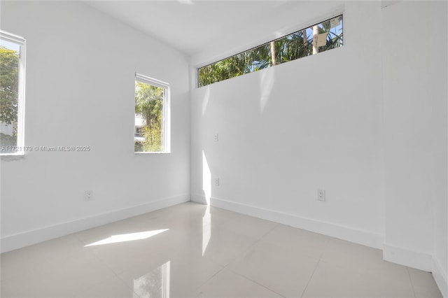 spare room with a healthy amount of sunlight and light tile patterned floors