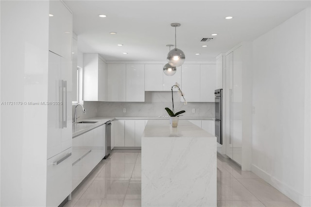 kitchen with white cabinetry, sink, a center island, decorative light fixtures, and appliances with stainless steel finishes