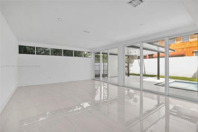 tiled spare room with a wall of windows