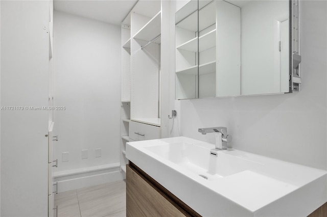 bathroom with a shower, tile patterned flooring, and vanity