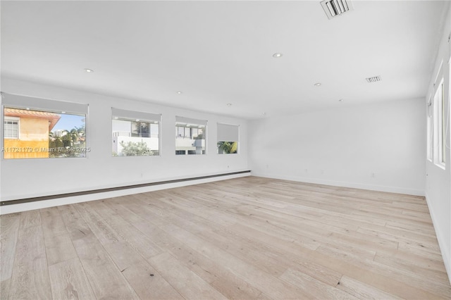 unfurnished room with light hardwood / wood-style floors and baseboard heating