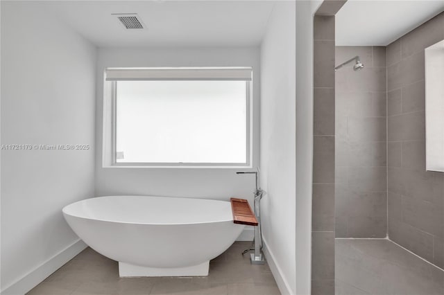 bathroom with separate shower and tub and tile patterned flooring