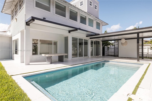 rear view of house featuring a patio area and a fenced in pool