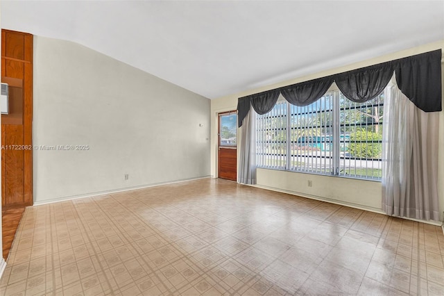 spare room featuring plenty of natural light and lofted ceiling