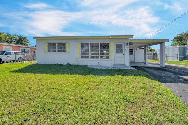 view of front of home with a front yard and a carport