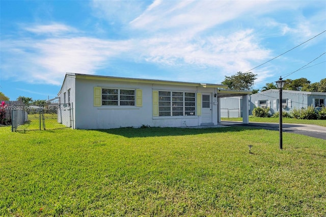 view of front of property with a front lawn and a carport