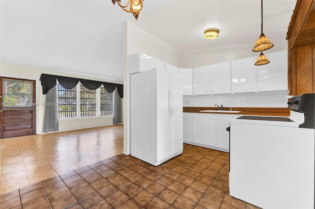 kitchen featuring sink, white refrigerator, decorative light fixtures, white cabinets, and range