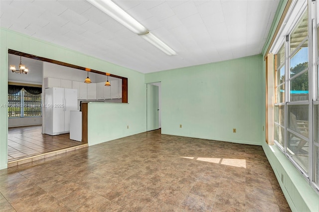 spare room with an inviting chandelier and a healthy amount of sunlight