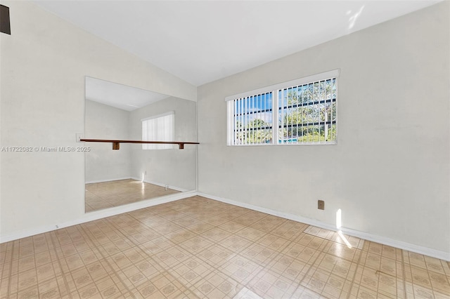 spare room featuring lofted ceiling