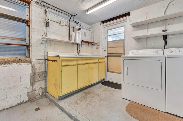 laundry room with washing machine and clothes dryer and cabinets