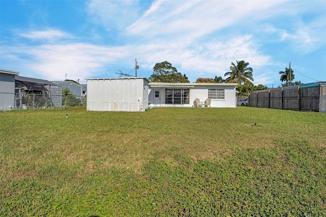 rear view of property featuring a lawn