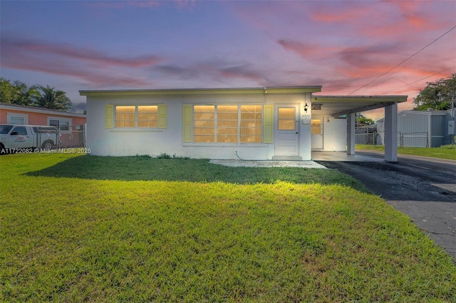 view of front of property featuring a yard and a carport