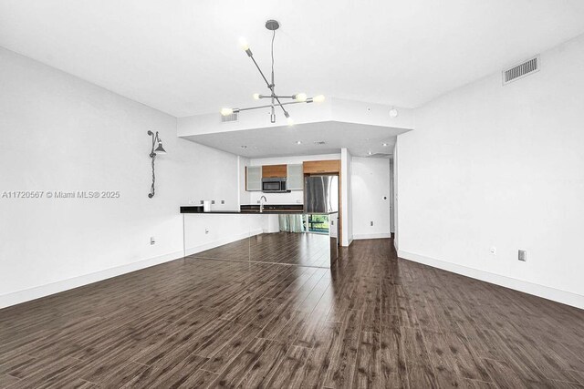 kitchen with floor to ceiling windows, sink, hanging light fixtures, stainless steel appliances, and dark hardwood / wood-style flooring