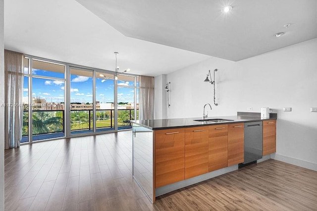 kitchen with floor to ceiling windows, dishwasher, sink, hanging light fixtures, and a breakfast bar area