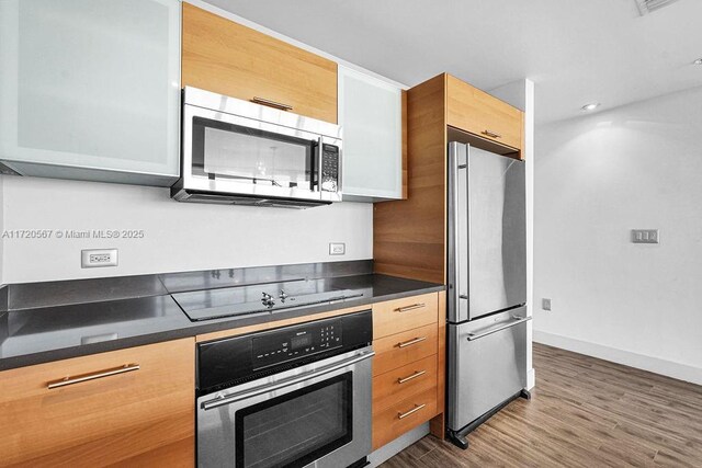 kitchen with hardwood / wood-style floors and stainless steel appliances