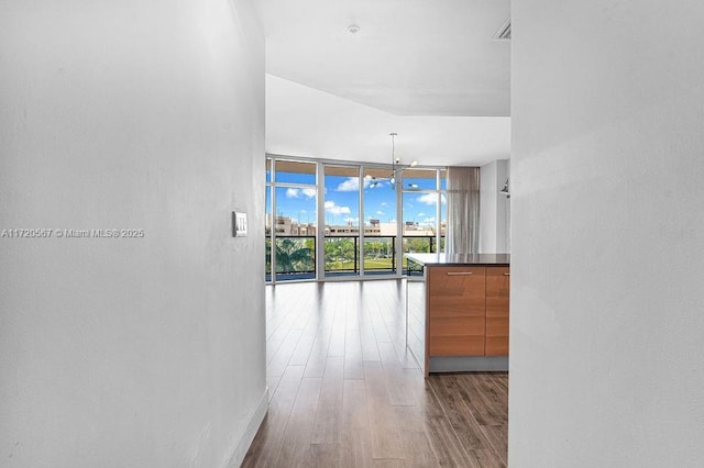 corridor with floor to ceiling windows, light hardwood / wood-style flooring, and a notable chandelier