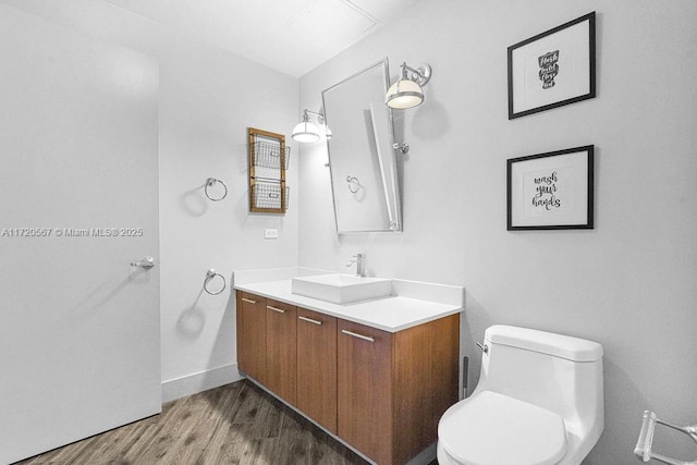 bathroom with toilet, vanity, and hardwood / wood-style flooring