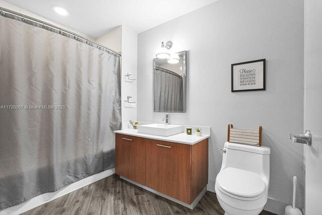 bathroom featuring wood-type flooring, vanity, and toilet