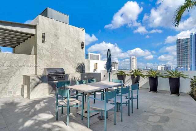 view of patio featuring area for grilling, a grill, and exterior bar