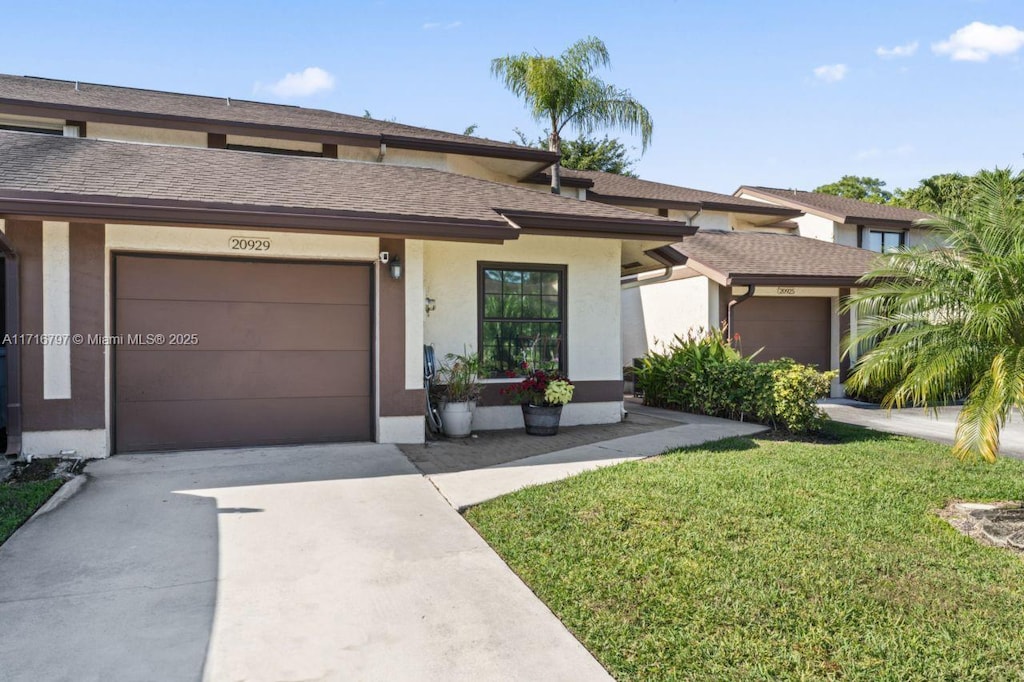 view of front of home with a front yard and a garage