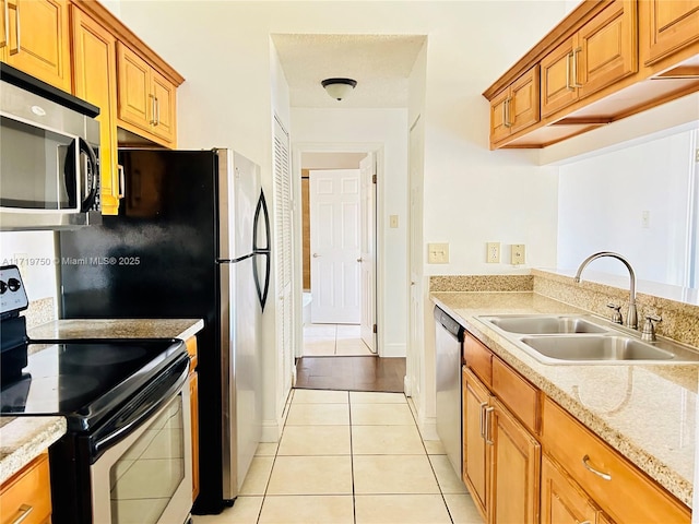 kitchen featuring light tile patterned floors, stainless steel appliances, and sink