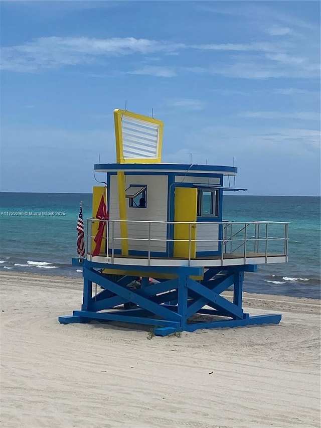 view of dock featuring a water view and a view of the beach