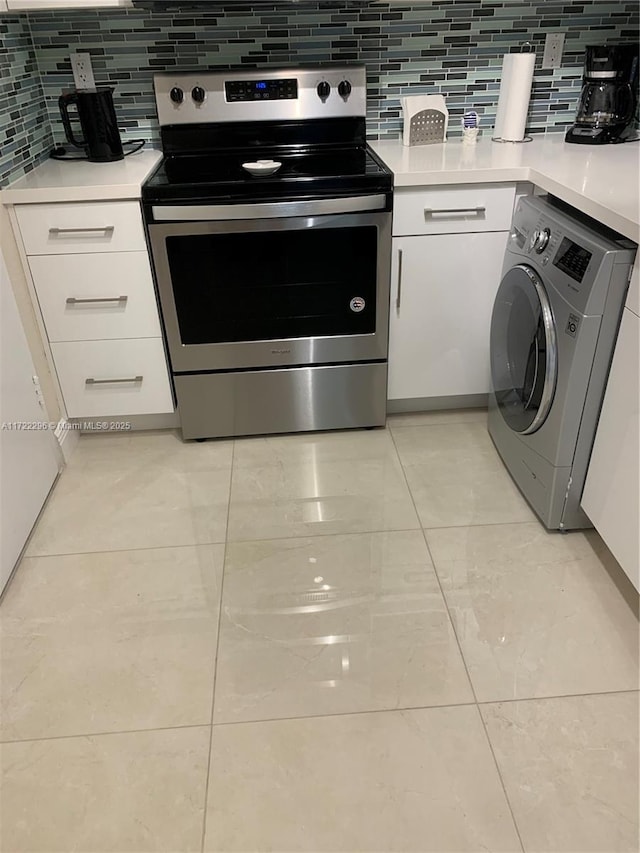 kitchen with stainless steel range with electric stovetop, white cabinetry, decorative backsplash, and washer / clothes dryer