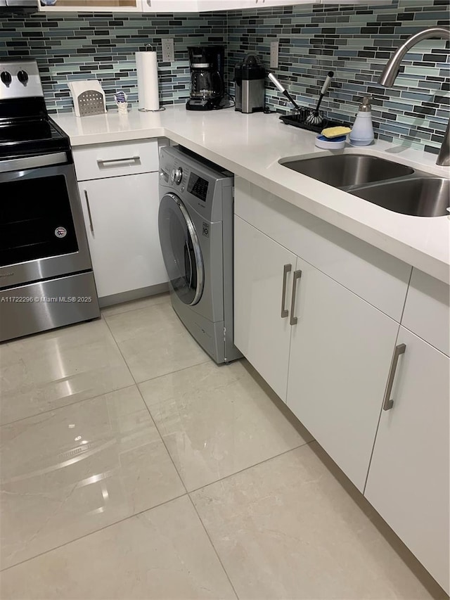 kitchen featuring washer / dryer, white cabinetry, tasteful backsplash, and electric stove