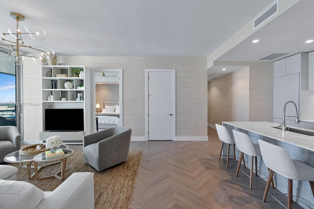 living room with parquet flooring, sink, and a notable chandelier