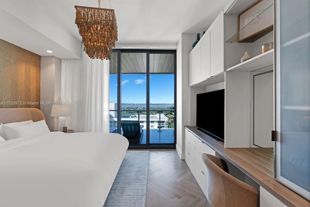 bedroom with built in desk, access to outside, floor to ceiling windows, and light parquet flooring