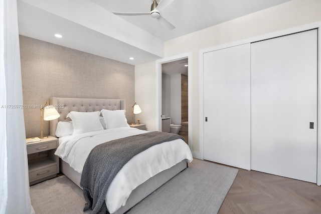 bedroom featuring ceiling fan, a closet, light parquet floors, and ensuite bathroom