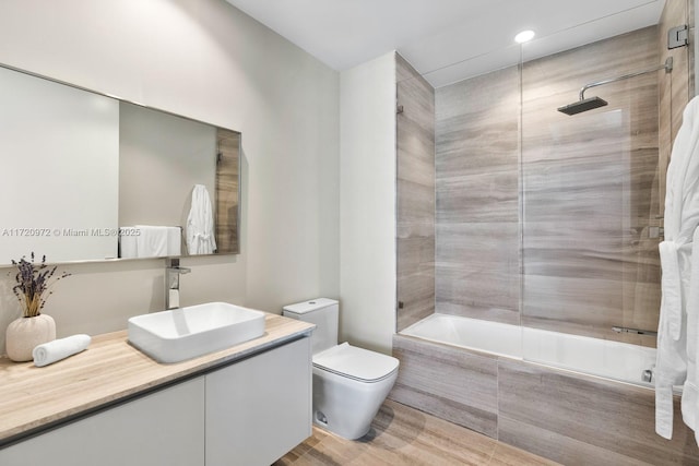 full bathroom featuring tiled shower / bath combo, vanity, and toilet