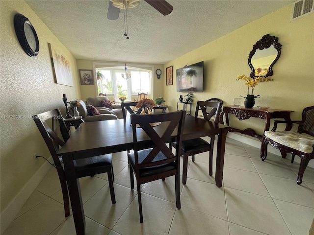 dining room featuring ceiling fan, light tile patterned floors, and a textured ceiling