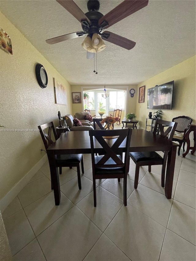 dining room with tile patterned floors, ceiling fan, and a textured ceiling