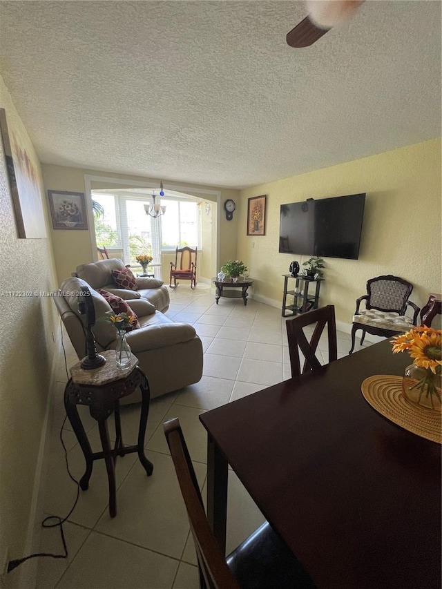 living room featuring light tile patterned floors, a textured ceiling, and ceiling fan