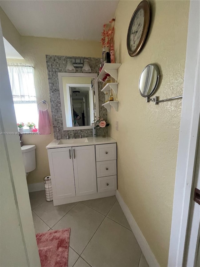 bathroom with tile patterned flooring, vanity, and toilet