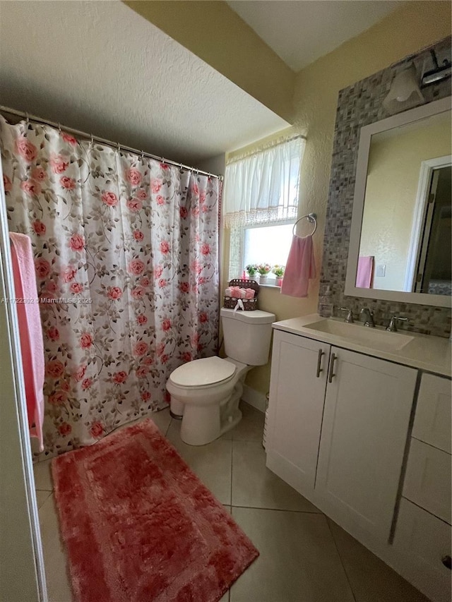 bathroom with tile patterned floors, a textured ceiling, vanity, toilet, and curtained shower