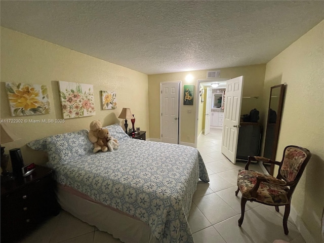 tiled bedroom featuring a textured ceiling