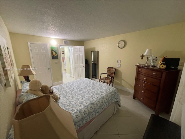 tiled bedroom featuring a textured ceiling