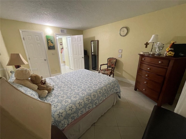 tiled bedroom featuring a textured ceiling