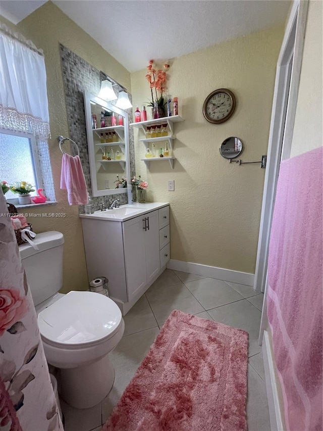 bathroom with toilet, vanity, and tile patterned floors