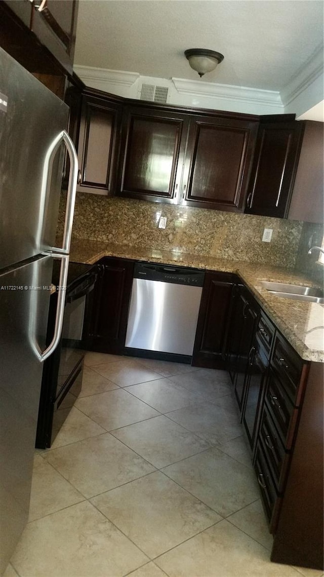 kitchen featuring backsplash, stone countertops, light tile patterned flooring, and stainless steel appliances