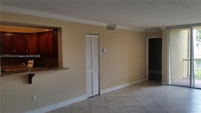 interior space featuring light tile patterned floors and crown molding