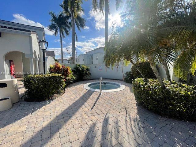 view of pool featuring a patio and a hot tub