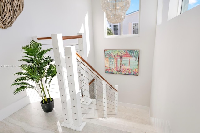 stairs featuring a high ceiling and an inviting chandelier